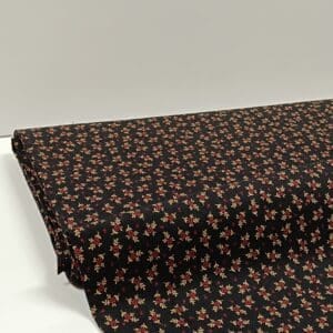 Tela negra con flores rojas y ramilletes crema