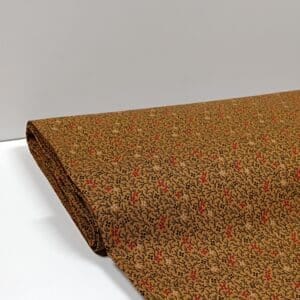 Tela ocre con flores rojas, negras y beige